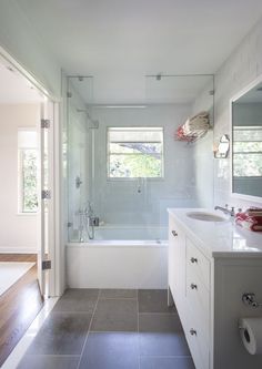 a bathroom with a sink, toilet and bathtub next to a window in it