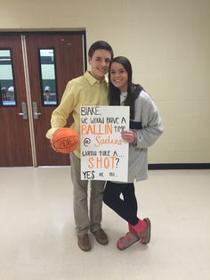 a man and woman holding a sign in an empty room