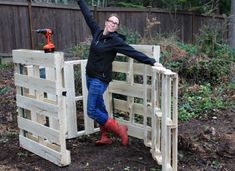 a woman standing in front of a wooden fence with the words how to build a compost bin out of wood pallets