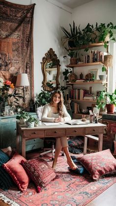 a woman is sitting at a desk in her home