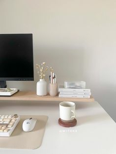 a desk with a computer monitor, keyboard and mouse on it next to other office supplies