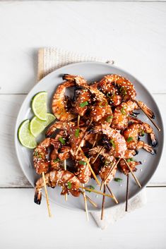 grilled shrimp skewers with lime wedges on a plate