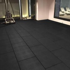 an empty gym room with black tiles on the floor