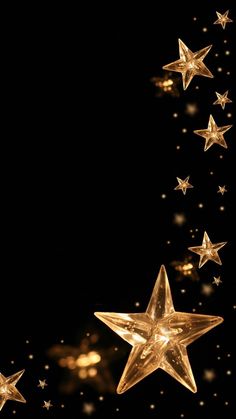 gold stars are flying in the air against a black background