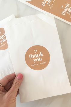 someone is holding up some thank you bags