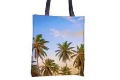 a tote bag with palm trees on the beach and blue sky in the background