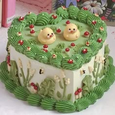 there is a cake with green frosting and two small teddy bears on the top