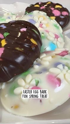 three decorated donuts sitting on top of a white plate with chocolate frosting and sprinkles