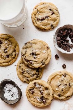 chocolate chip cookies with powdered sugar and spoons next to them on a white surface