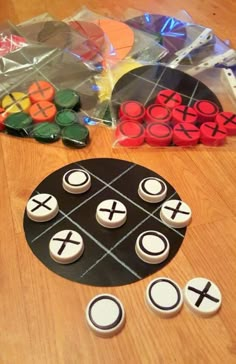 cupcakes and buttons on a table with plastic bags in the shape of tic - tacs