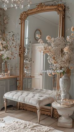 a room with a bench, mirror and flowers in it