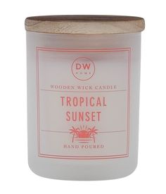 a white candle that is sitting on top of a wooden lid with the words tropical sunset written