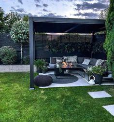 an outdoor living area with couches, tables and fire pit in the middle of it