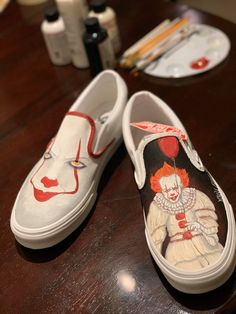 a pair of shoes painted with clowns on them sitting on a table next to other items