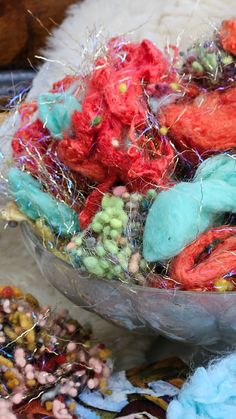 a bowl filled with lots of different colored yarns and sprinkles on top of a table