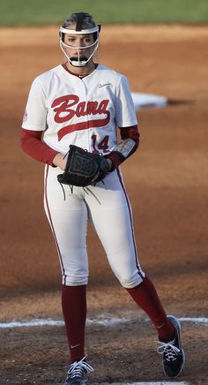 a female baseball player standing on the field with her mitt in hand and wearing a catchers mitt