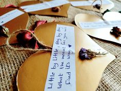 several pieces of paper with writing on them and dried flowers in front of the mirror