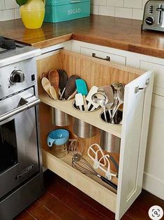 a kitchen with an oven, dishwasher and utensils in the drawer