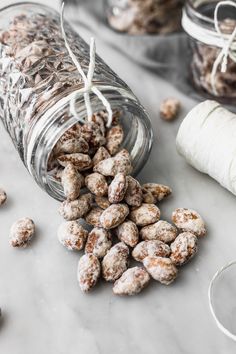 a glass jar filled with nuts next to some twine