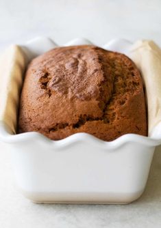 a close up of a loaf of bread in a white dish on a counter top