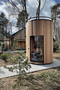 a round wooden structure in the middle of a forest