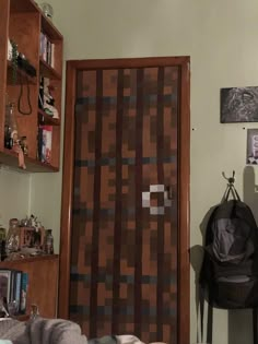 a room with a chair, bookshelf and a door that has squares on it