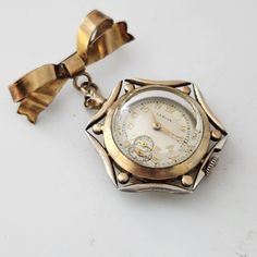 Elegant and Unique are the best ways to describe this 1940's Broach Watch from SWISS Maker LANCIA. Designed to be worn as a broach on a jacket or coat and with the dial set so that it is easily read whilst being worn. The ornate case and surround measure 29mm in total width, the material is identified as Gold Fill and the overall condition is excellent. The discreet winding crown is set in at the bottom of the watch. The original dial is in excellent condition with a small sub second dial at the Luxury Vintage Watch Accessories With Tachymeter, Vintage Self-winding Round Watch, Vintage Self-winding Watch, Vintage Silver Watch Accessories, 1940s Jewelry, Watch For Ladies, Vintage Timepiece, Women Wrist Watch, Swiss Made