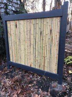 a sign made out of bamboo sticks in the woods