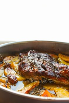 a pan filled with meat and vegetables on top of a table