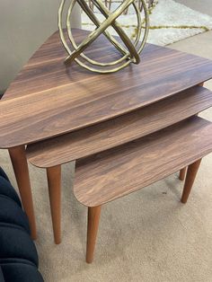 three wooden tables stacked on top of each other in a room with carpeted flooring