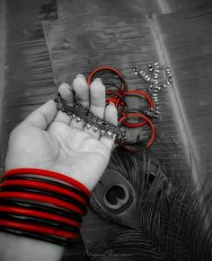 a woman's hand holding several bracelets on top of a table