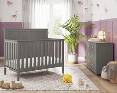 a baby's room with purple walls and furniture