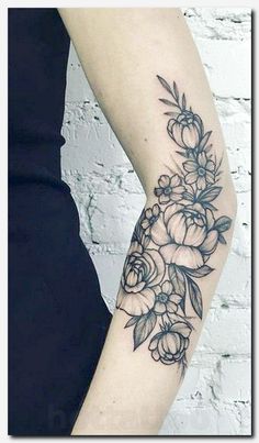 a woman's arm with flowers and leaves tattooed on the side of her arm