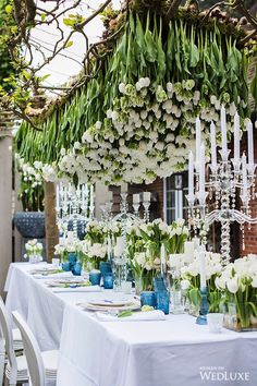 the table is set with white flowers and candles