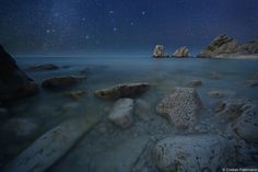 some rocks and water under a night sky