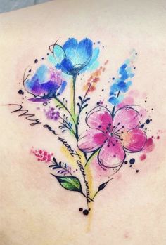 a watercolor flower tattoo on the back of a woman's upper arm and shoulder