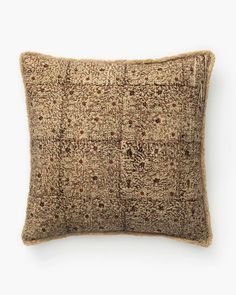 a brown and tan pillow on a white background with an intricate pattern in the middle