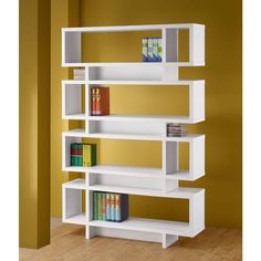 a white book shelf with books on top of it in front of a yellow wall