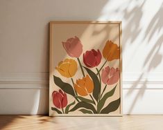 there is a framed painting on the wall with tulips painted on it in orange, pink and yellow