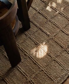 the sun shines through the windows on an area rug that has been placed in front of a wooden table