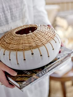 a person holding a basket on top of magazines