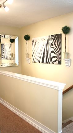 there is a zebra painting on the wall next to the bannister in this house