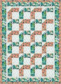 an orange and green quilt with white flowers on the border is featured in this image