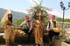 three people dressed in costumes posing for the camera with baskets of food on their hands