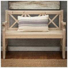 a wooden bench with two pillows on it