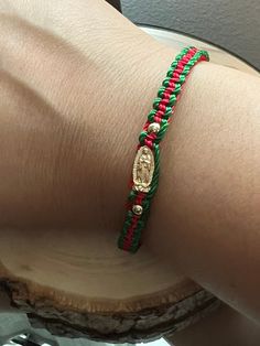 a close up of a person wearing a bracelet on their arm with a gold coin