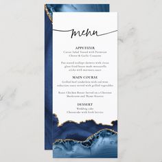 an elegant blue and gold menu card with the word, menu written in black ink