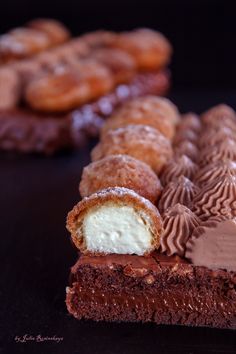 chocolate desserts and pastries are arranged on a black surface