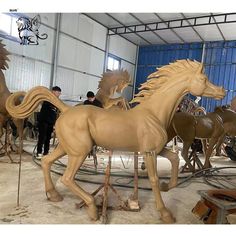 several wooden horses are being worked on in a factory