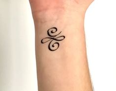 a small wrist tattoo with the letter s on it